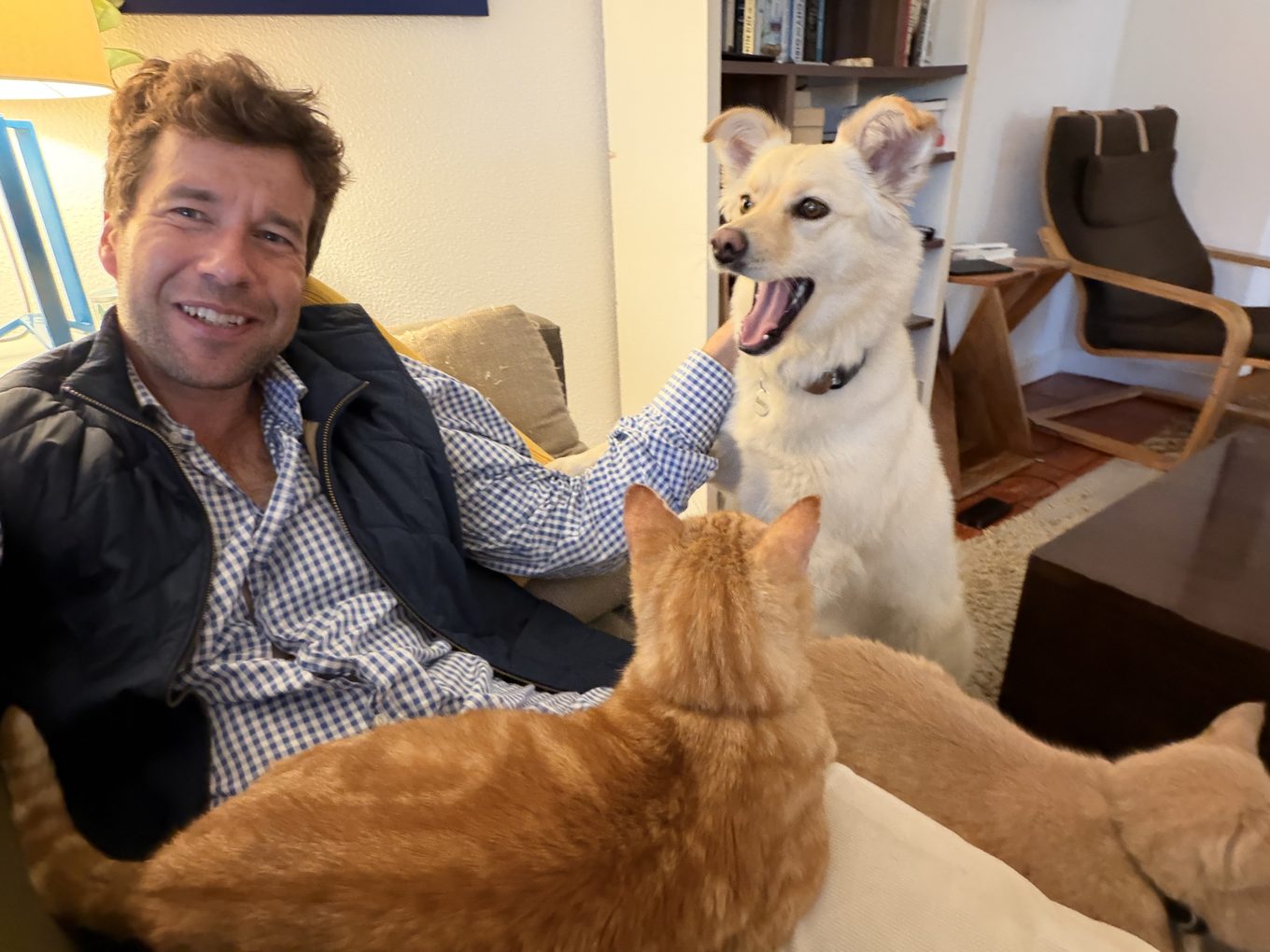 David on the sofa at home with his dog Bailey and his two cats, Oscar and Bodhi